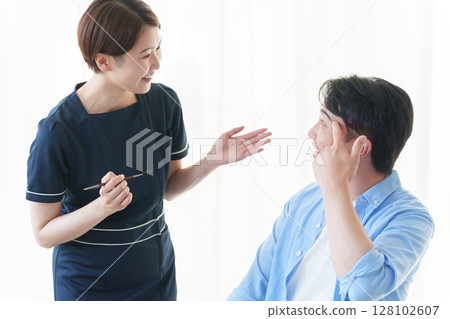 一位男士正在接受美容顧問的修眉服務 128102607