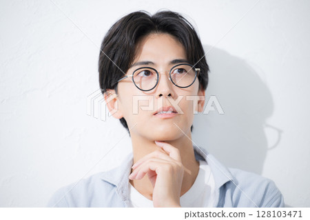 特寫鏡頭：一位戴著眼鏡、微笑、抬頭的清爽男士 128103471