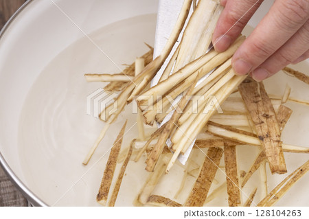 Steps for making Kinpira Gobo in the kitchen: Soak the burdock in water to remove the bitterness 128104263