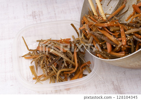 將準備好的金平牛蒡轉移到儲存容器中。 將準備好的金平牛蒡轉移到儲存容器中。 128104345