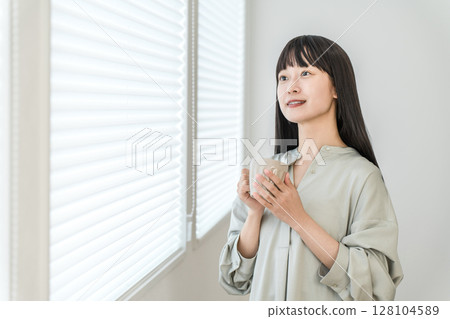 年輕的亞洲女性在窗邊喝熱飲、茶、咖啡 128104589