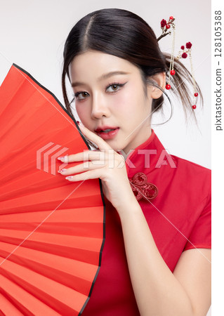 Portrait of joyful beauty Asian woman in red Cheongsam Chinese traditional dress holding red fan isolated on white background for Chinese New Year festival content. 128105388