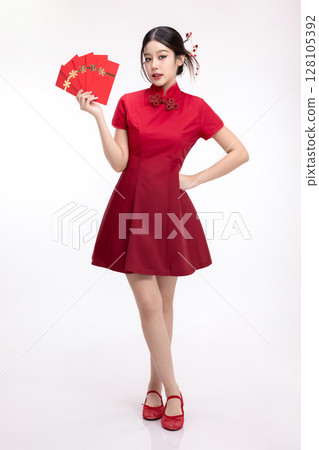 Portrait of joyful beauty Asian woman in red Cheongsam Chinese traditional dress celebrating with lucky red envelopes on Chinese New Year festival isolated on white background. 128105392
