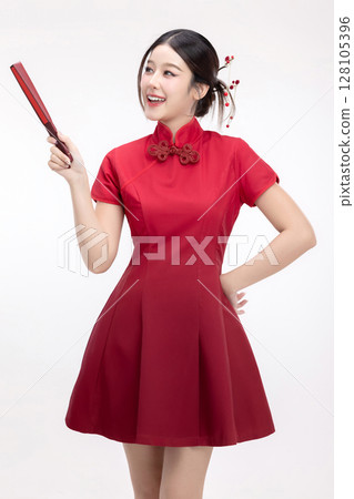 Portrait of joyful beauty Asian woman in red Cheongsam Chinese traditional dress pointing red fan isolated on white background. For Chinese New Year festival content. 128105396