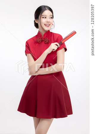 Portrait of joyful beauty Asian woman in red Cheongsam Chinese traditional dress pointing red fan isolated on white background. For Chinese New Year festival content. Portrait of joyful beauty Asian woman in red Cheongsam Chinese traditional dress pointing red fan isolated on white background. For Chinese New Year festival content. 128105397