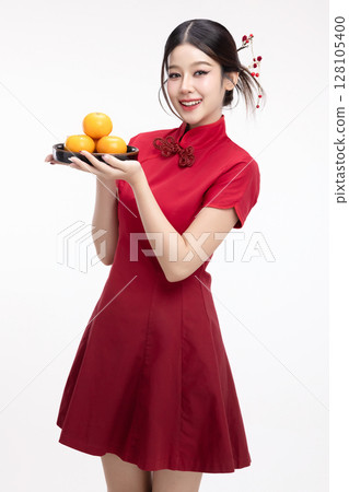 Portrait of joyful beauty Asian woman in red Cheongsam Chinese traditional dress celebrating with lucky fresh oranges on Chinese New Year festival isolated on white background. 128105400