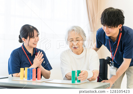 在護理和復健機構工作的職業治療師以及正在接受復健治療的老年女性 128105423