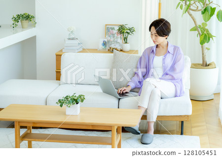 Middle-aged woman using a laptop in her room 128105451