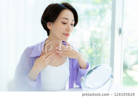 Middle-aged woman doing skin care Middle-aged woman doing skin care 128105620