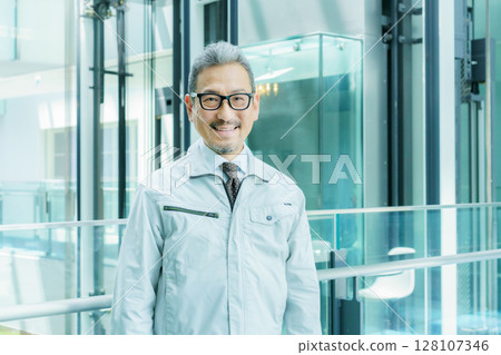 Middle-aged worker standing in an office building. Photo courtesy of Sky Perfect Tokyo Media Center. 128107346