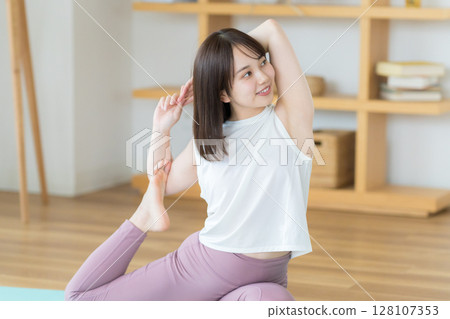 Young woman doing yoga in the living room 128107353