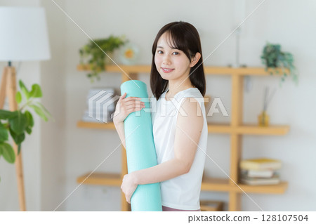 Young woman doing yoga in the living room 128107504
