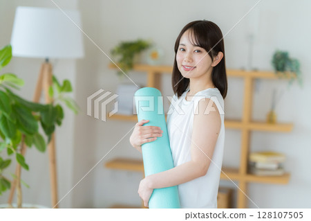 Young woman doing yoga in the living room 128107505