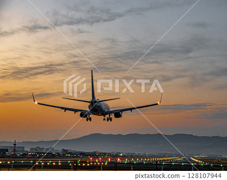 Jet plane landing at dusk 128107944