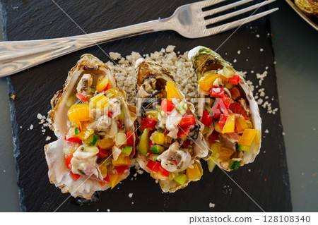Delicious Oysters with Vibrant Salsa and Fork on Slate Platter, a Culinary Delight Delicious Oysters with Vibrant Salsa and Fork on Slate Platter, a Culinary Delight 128108340