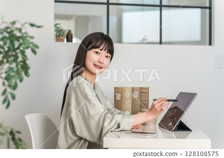 Young Asian, Japanese woman operating tablet PC at home, office 128108575