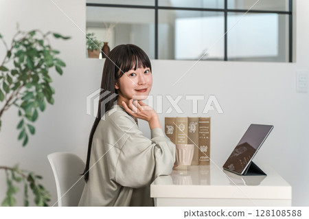 Young Asian, Japanese woman using tablet pc at home, office Young Asian, Japanese woman using tablet pc at home, office 128108588