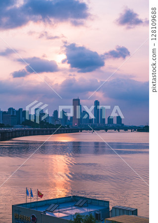 A view of the sunset city of Yeouido in the financial district taken on the Dongjak Bridge on the Han River in summer evening 128109688