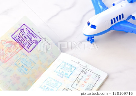Image of japanese passport with open visa page and airplane, planning to travel abroad for long vacation Image of japanese passport with open visa page and airplane, planning to travel abroad for long vacation 128109716