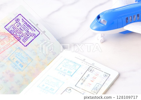 Image of japanese passport with open visa page and airplane, planning to travel abroad for long vacation 128109717