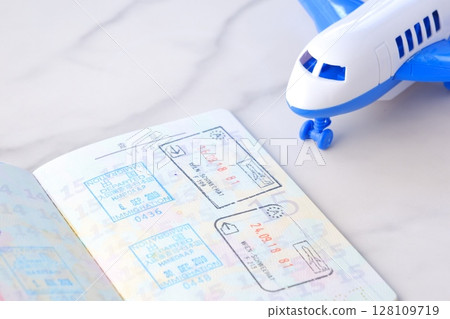 Image of japanese passport with open visa page and airplane, planning to travel abroad for long vacation 128109719