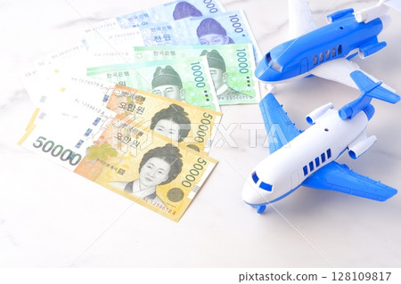 Image of departing for a trip to Korea with Korean won (KRW) banknotes and an airplane 128109817