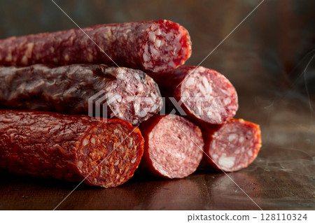 Smoked and dry cured sausages on a wooden table. Smoked and dry cured sausages on a wooden table. 128110324