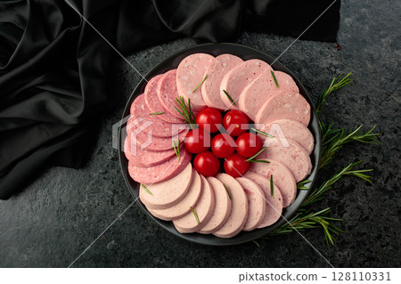 Various boiled sausages with tomatoes and rosemary. 128110331