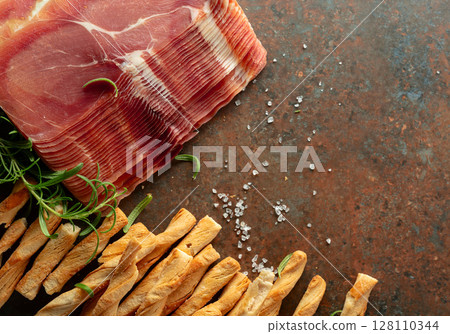 Prosciutto with bread sticks and rosemary. 128110344