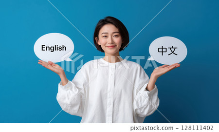 Woman in white shirt holds two speech bubbles, polyglot one with English and other with Chinese, against blue background Woman in white shirt holds two speech bubbles, polyglot one with English and other with Chinese, against blue background 128111402