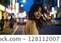 Woman walking downtown at night 128112007