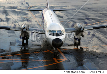 A propeller plane arriving at an airport in winter 128112931