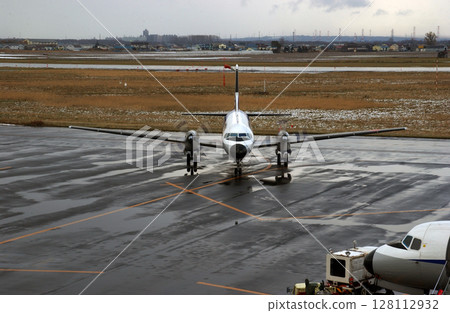 A propeller plane arriving at an airport in winter 128112932