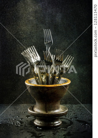 Still life with forks in a vase under drip irrigation 128113470