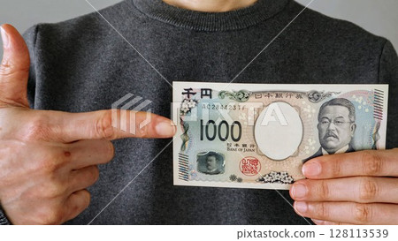 Person pointing at the new 1,000 yen bill 128113539