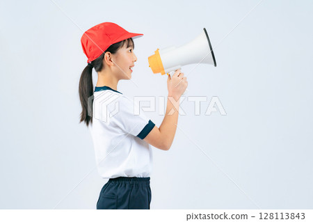 一個穿著運動服的女孩用擴音器歡呼 一個穿著運動服的女孩用擴音器歡呼 128113843
