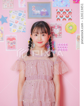 在粉紅色的房間裡拍攝的一個女孩的肖像 128113851