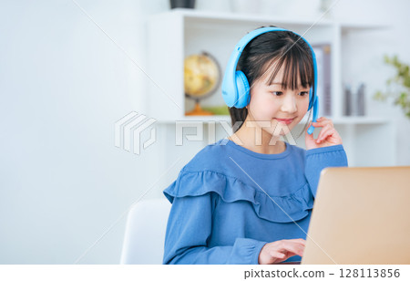 Girl wearing headphones and studying on a laptop 128113856