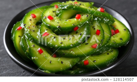 A long banner format photo captures a top view of a healthy vegan salad, comprising watermelon radish, avocado, lettuce, microgreen cucumber, and radish, all neatly arranged on a white plate 128114507