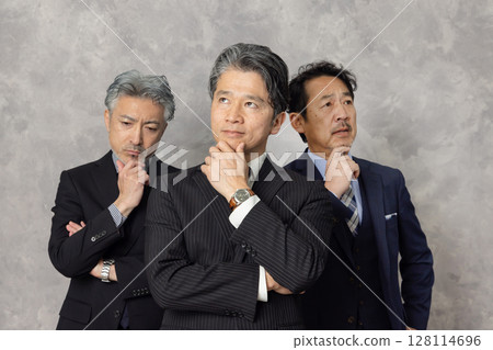 A group of middle-aged male business people thinking 128114696