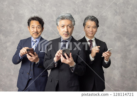 Middle-aged male business person searching on smartphone Middle-aged male business person searching on smartphone 128114721