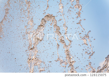 Splashes and jets of water against light background. 128115075