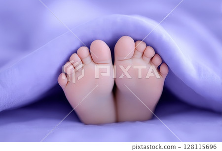 A baby girl's feet are wrapped in a pastel pink blanket in this closeup shot 128115696
