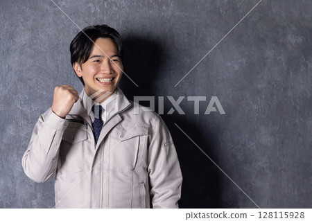 A man wearing work clothes and doing a guts pose A man wearing work clothes and doing a guts pose 128115928