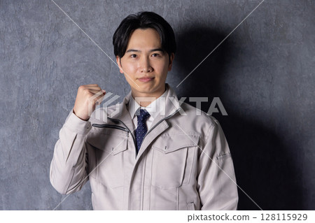 A man wearing work clothes and doing a guts pose A man wearing work clothes and doing a guts pose 128115929