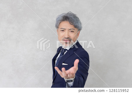 A middle-aged businessman grabbing something on his palm A middle-aged businessman grabbing something on his palm 128115952