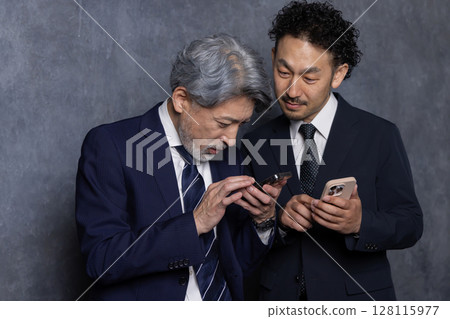 Middle-aged businessman searching on smartphone 128115977