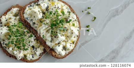 On a dairy base, rye bread is topped with microgreen and tofu 128116074