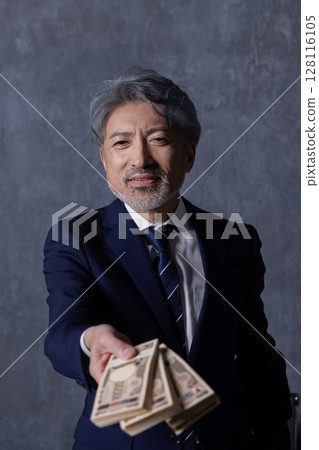 Smiling senior businessman holding a stack of bills 128116105