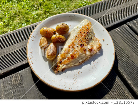 plate of grilled fish and potatoes 128116572